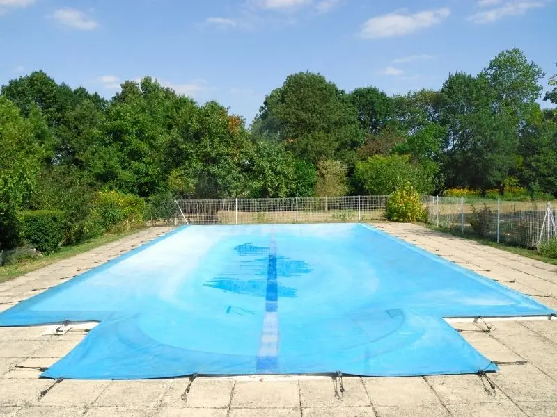 pool with fully closed pool cover surrounded by greenery